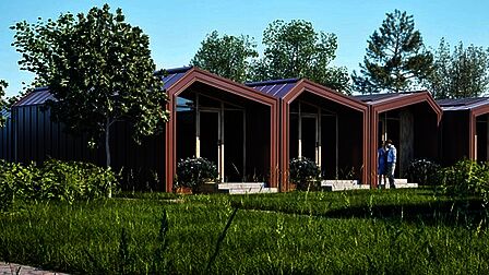 3 woonunits (containers met lazen wand aan het uiteinde) naast elkaar in een groene omgeving. 2 mensen staan voor een van de units