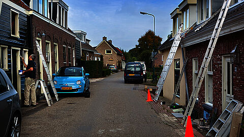 Straat met huizen met ladders aan voorzijde