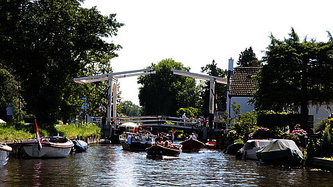 Een foto van enkele boten die op de Vecht varen bij de brug in Breukelen